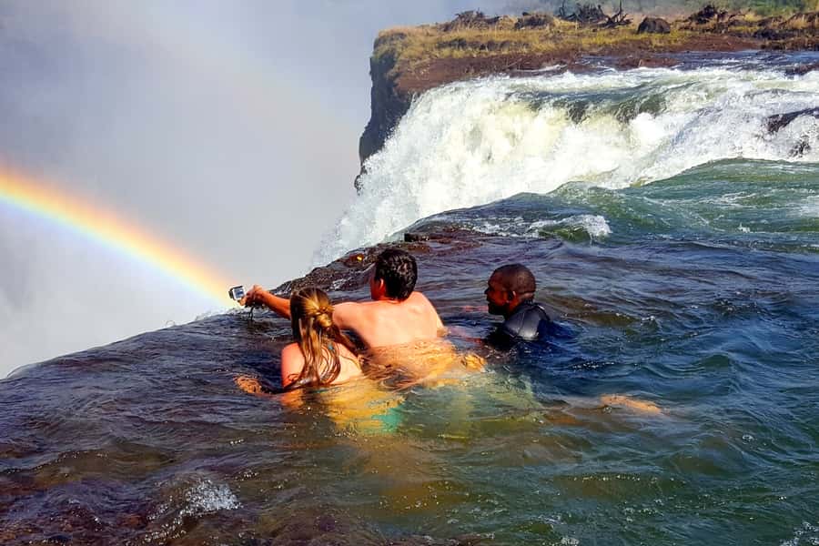 From Victoria Falls: Livingstone Island Tour & Devils Pool - Sitting beside Victoria Falls in Devil’s Pool