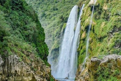 Tamul waterfall and water cave on a wooden canoe